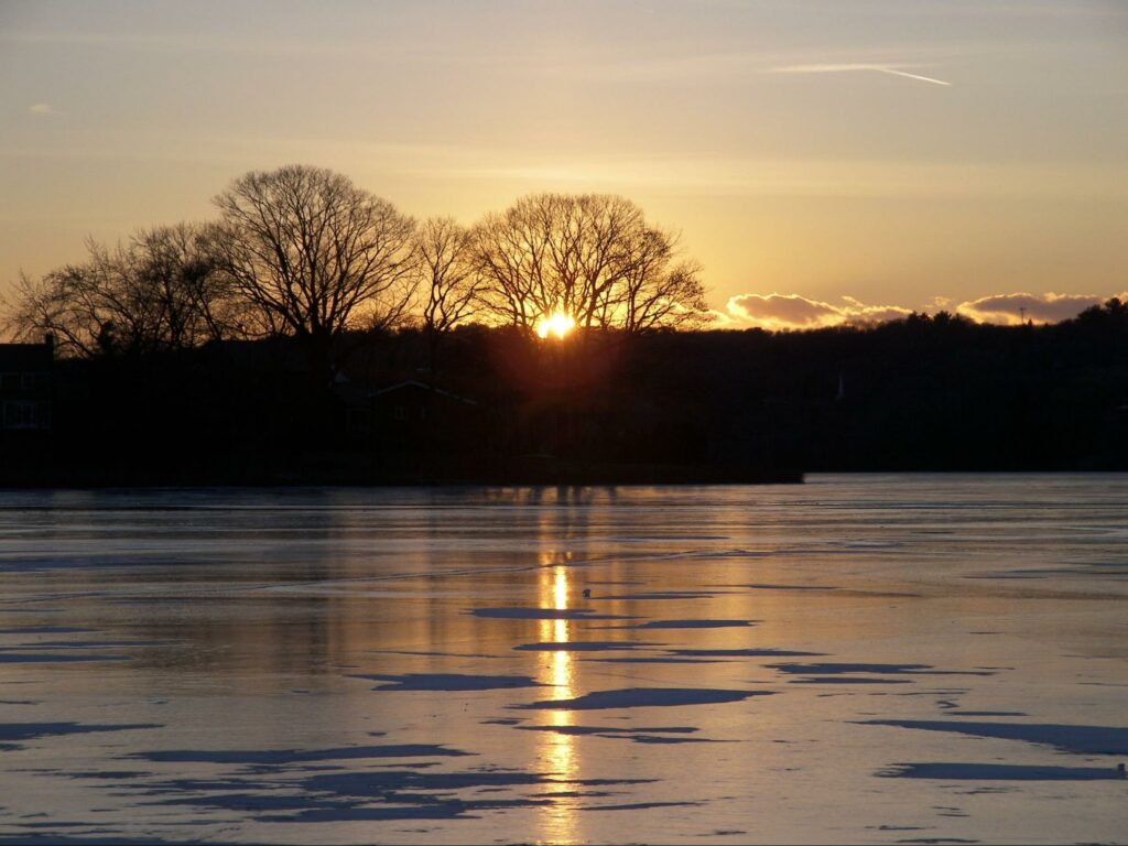 Sunset over frozen Spy Pond. 