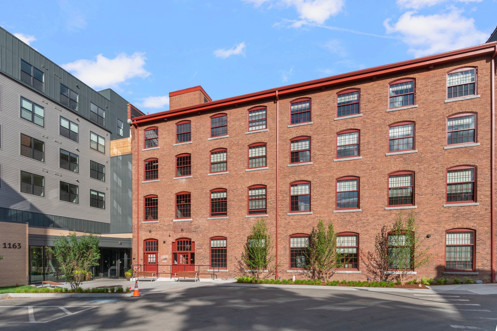 The Artemis Arlington. An old brick factory building attaches to a new modern building with beautiful landscaping in front.