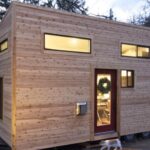 A modernist tiny house with bare wooden exterior walls.